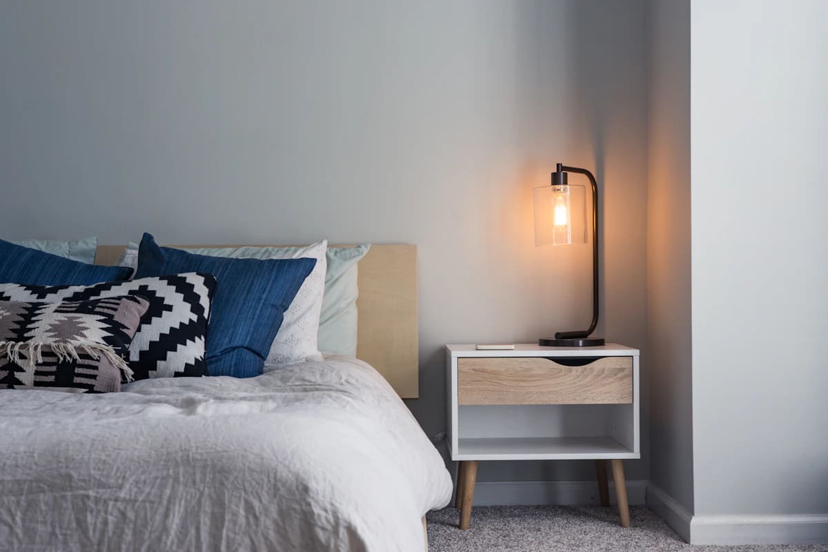 Black metal bedside lamp with exposed bulb