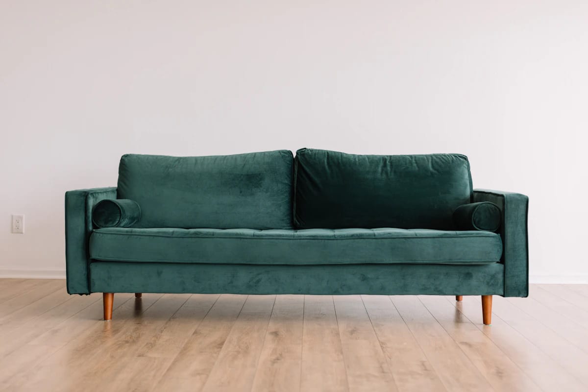 Emerald green velvet sofa with tapered legs