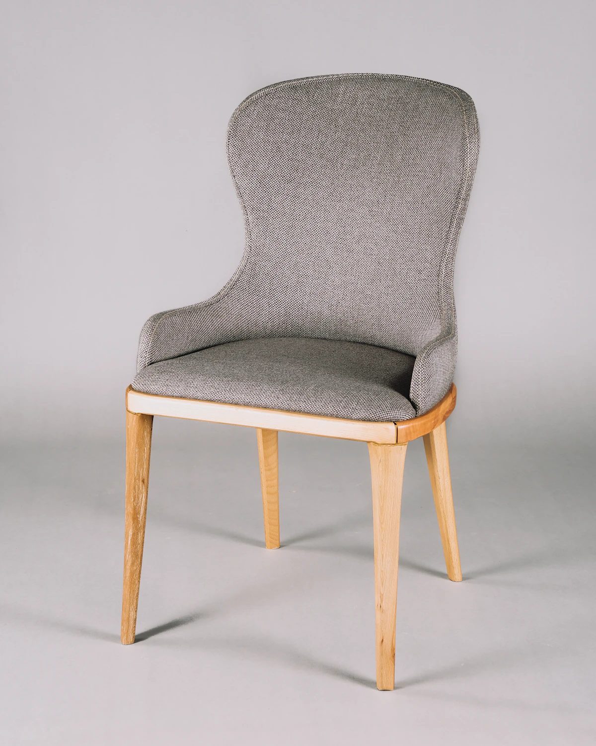 Grey wool-upholstered dining chair with oak legs